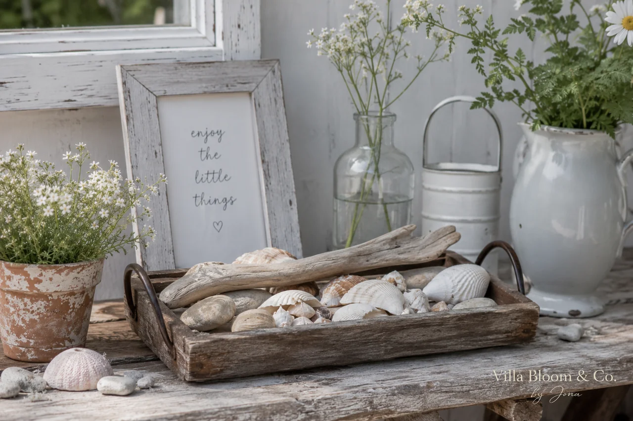 Vintage Holztablett mit Muscheln, Treibholz und Steinen, daneben Rahmen mit Spruch enjoy the little things, Wildblumen und weißer Krug